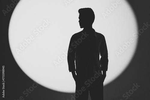 Artistic black and white silhouette of a man standing confidently in soft studio light with minimalistic composition