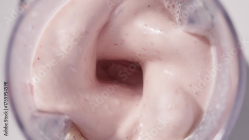 Strawberry and banana pink milkshake blended in blender with splashes. top view. slow motion. Healthy protein smoothie drink concept , food closeup