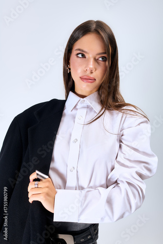 Wallpaper Mural Stylish young woman poses gracefully in autumn outfit in a grey studio setting Torontodigital.ca