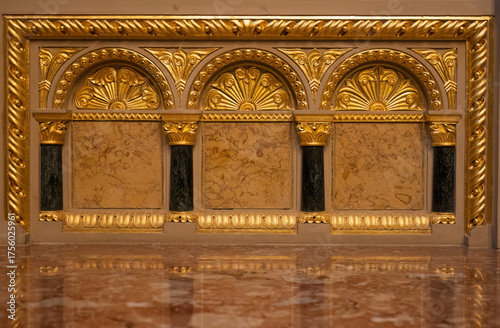 Architectural detail with gold arches and marble panels

