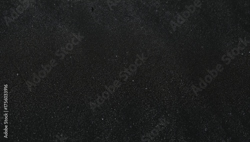 Close-up shot of dark volcanic sand grains with detailed texture
