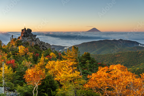 秋の奥秩父山塊天狗峰から紅葉の天狗岩の朝日に輝く天空の剣と朝焼けの富士山