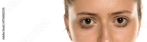 Studio shot of young woman closeup face with mascara smudged under eyes on white background.