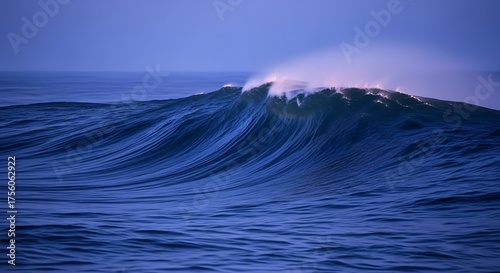 Fototapeta Naklejka Na Ścianę i Meble -  Powerful ocean wave cresting with foam against a blue sky.