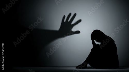 vector illustration of a woman sitting on the floor with head down and shadow of a raised hand on the wall to symbolize fear and abuse domestic violence, woman, fear, abuse, shadow, raised hand, 