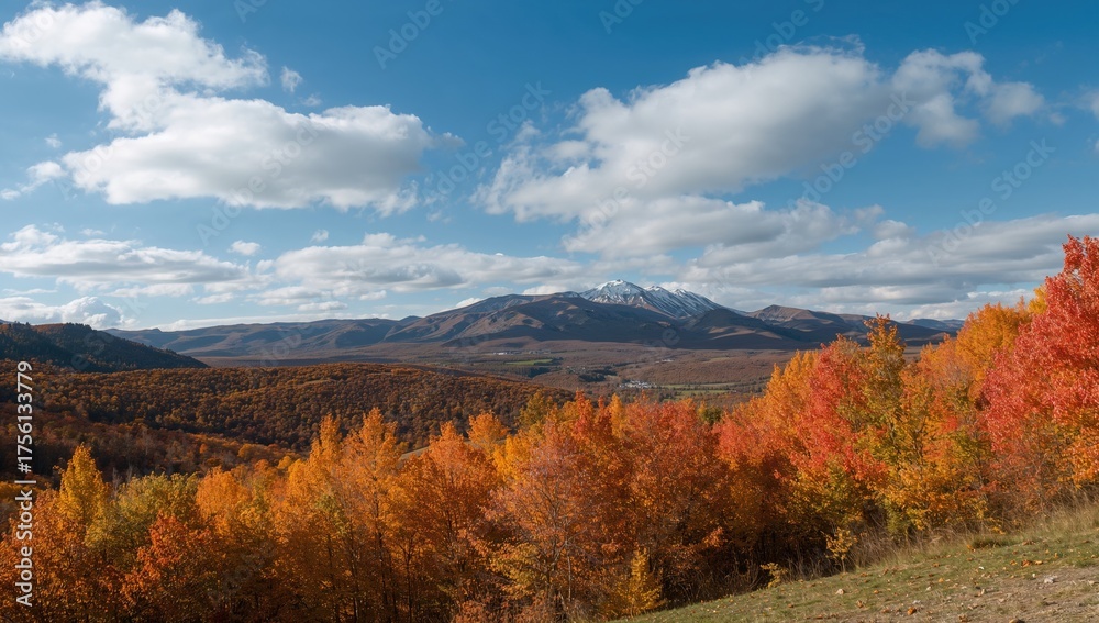 Fototapeta premium Vibrant Fall Leaves Displayed Under Clear Blue Sky with Fluffy Clouds, Hills and Mountains in the Distance