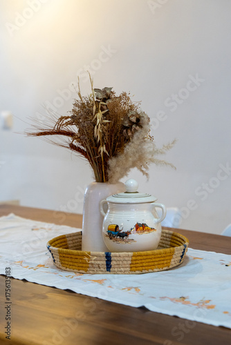 Pot and flower arrangement on table.