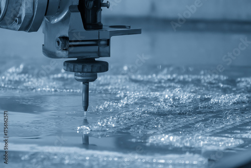 Close-up scene of multi-axis abrasive waterjet cutting machine cut the aluminum plate in the light blue scene