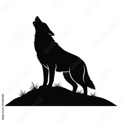 A howling wolf stands proudly upon a grassy knoll silhouette