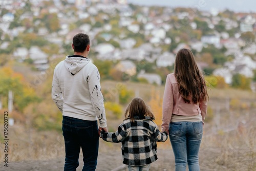 Family Walking With Pet Golden Retriever Dog Along Autumn Woodland Path Together