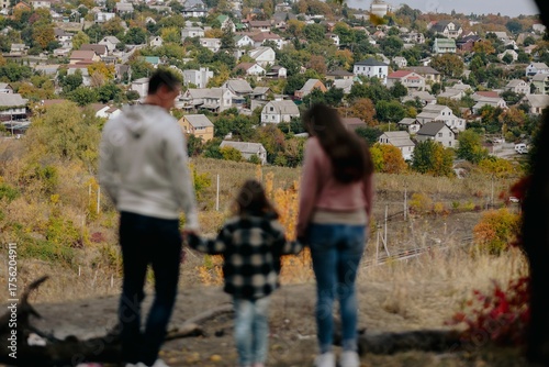 Family Walking With Pet Golden Retriever Dog Along Autumn Woodland Path Together