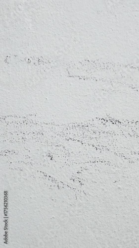 Vertical video showing close-up of old white wall with stains and rough texture surface, perfect for background or grunge design use.