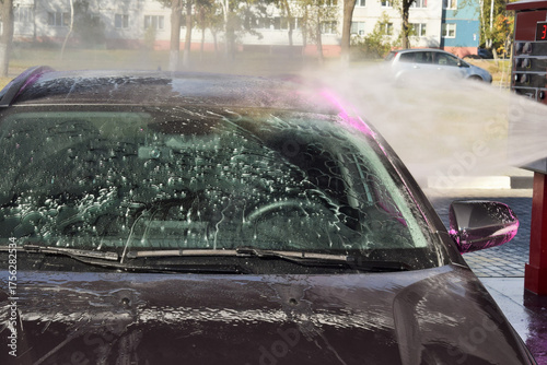 man worker washing car on a car wash