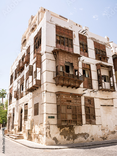 Historic building facade with traditional wooden windows and balconies in Al-Balad, Jeddah, Saudi Arabia.