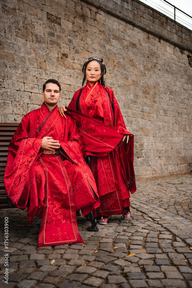 Fototapeta premium Multicultural wedding couple posing in traditional Chinese hanfu clothing