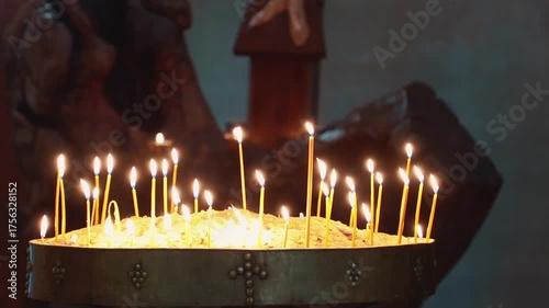 Christian candles in church glowing in golden light. Concept of sacred space, religion, remembrance, and the emotional purity of prayer. Jib shot at the crucifixion of Jesus Christ, from bottom to top