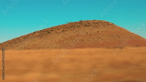 Beautiful view of the rusty desert hills, from the window of a moving vehicle. Clay plateaus and savannas of Georgia. Hand hold shot.