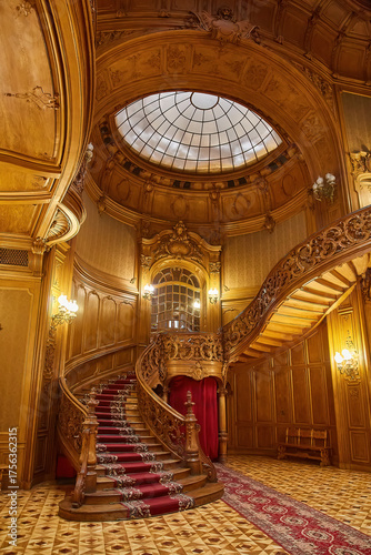 Luxurious carved wooden staircase in a historic mansion interior.
