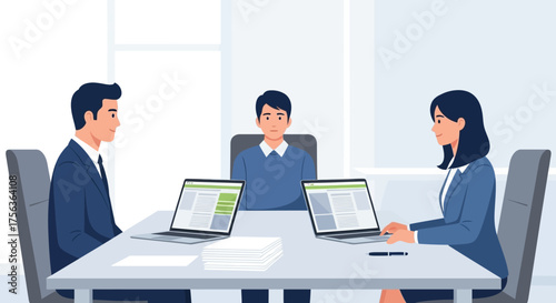 Business meeting in a modern office with three professionals discussing a project at a table with laptops