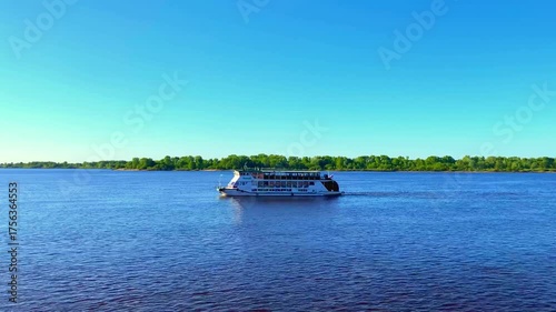 NIZHNY NOVGOROD, RUSSIA - MAY 20, 2024: View at the Volga River. A boat drifts slowly on the Volga's calm waters, while birds soar gracefully through the sky, embracing the tranquil flow of nature
