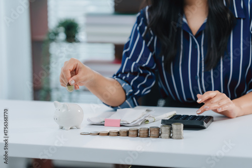 Cuadro en lienzo Saving with Vision: A woman meticulously tends to her financial planning, adding a coin to her piggy bank