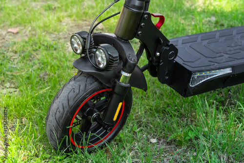 Electric scooter front with dual headlights and thick tire close-up