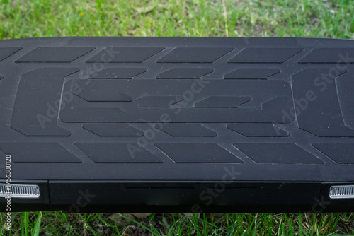 Electric scooter deck with geometric grip and LED lights close-up, electric scooter concept