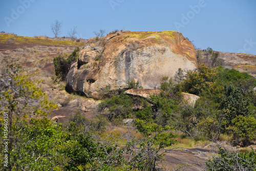 Large rock and sparse vegetation in an arid landscape