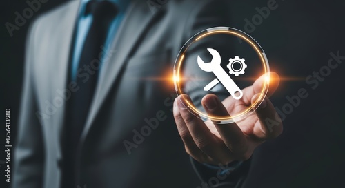 Man in suit holding a digital wrench and gear icon with glowing orange light hand