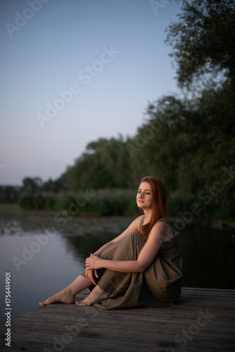 Red-haired Woman Reflecting by the Lake at Dusk