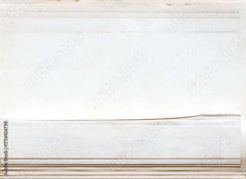 Close-up of a stack of very old, yellowed, and lightly stained white paper with a subtle texture. Blank background with copy space for design or mockup.