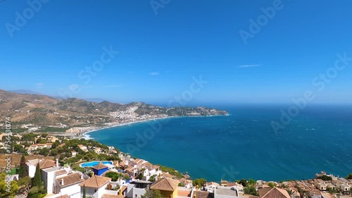 Panoramic view of the Mediterranean Sea with turquoise water, coastal hills, and clear blue sky in La Herradura, Andalusia, Southern Spain.