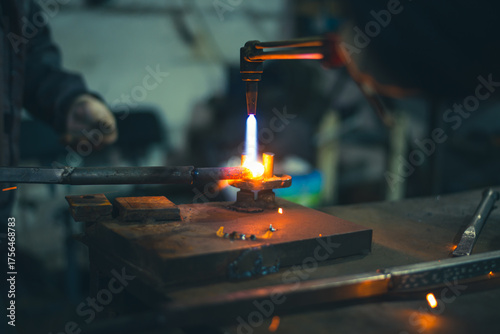 Workers of the blacksmith's workshop heat the metal part to red, for further forging and giving the desired shape. High quality photo