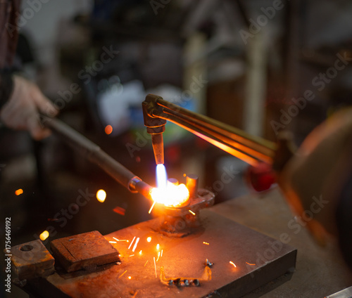 Workers of the blacksmith's workshop heat the metal part to red, for further forging and giving the desired shape. High quality photo