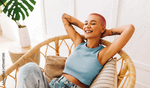 Photography A young woman with short hair sits comfortably in a stylish chair, smiling joyfully