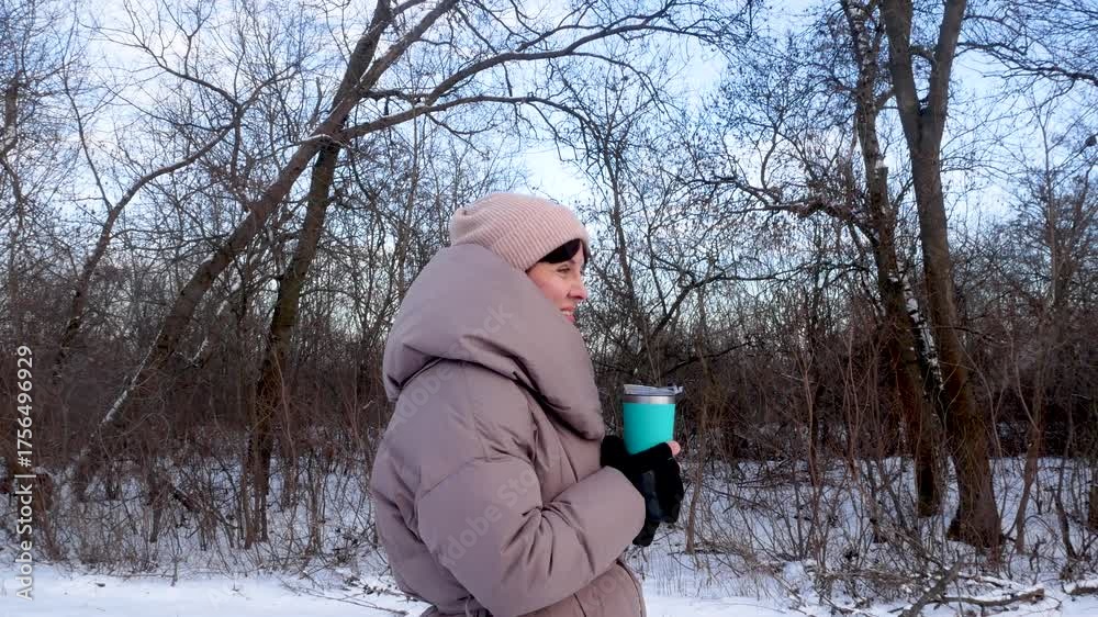 custom made wallpaper toronto digitalA woman in a warm down jacket drinks hot tea from a thermal cup in the winter forest. A walk in the park, forest in winter. Snowy cold winter.