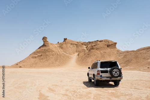 Off road car near Ong Jemel, the Camel Neck Rock. Sahara Desert near Tozeur, Tunisia.