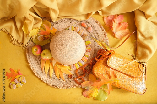 still life with yellow leaves, apples and hat