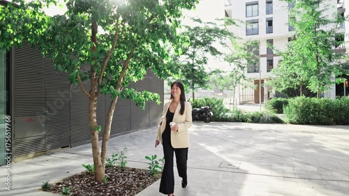 Businesswoman walking in urban environment, slow motion