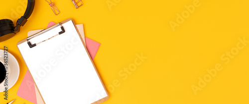 Banner with blank clipboard mockup, stationery and cup of coffee on a yellow background.