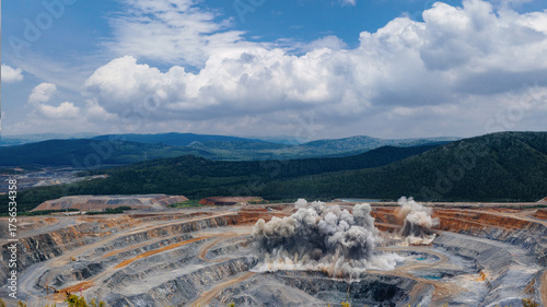 Foto Dynamic open pit gold ore mining operations with explosive detonation in vast la
