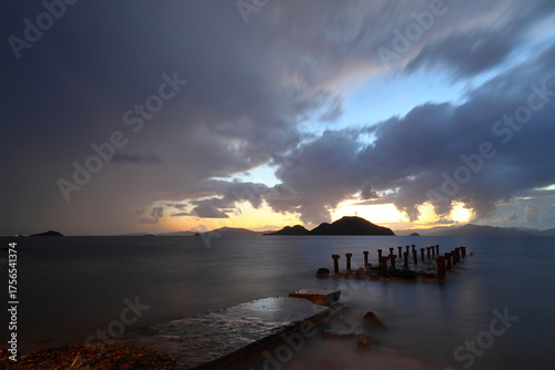 Heavy, storm clouds over the ocean, herald the arrival of a storm. Beautifully illuminated dark clouds and reflections in the ocean water