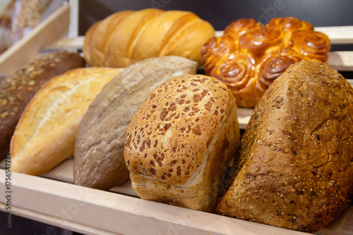 Assortment of freshly baked artisan breads on wooden shelves bakery sourdough