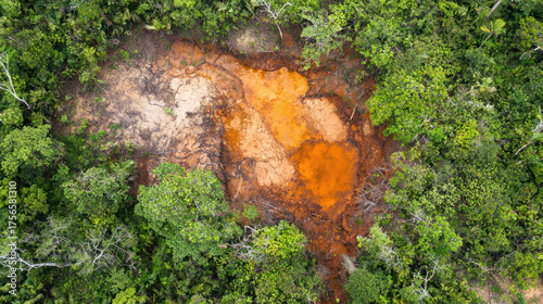 Aerial view of deforested area with exposed earth amid lush green jungle canopy