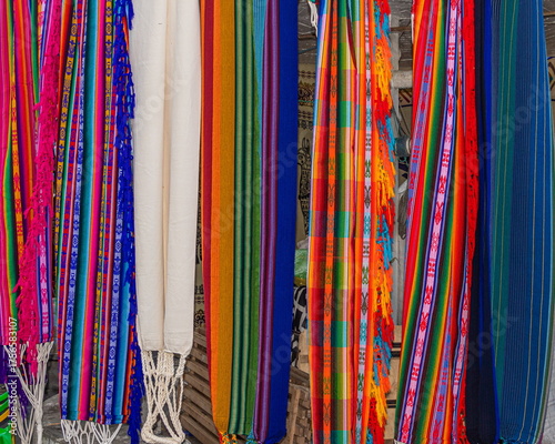 Brightly colored fabric hammocks are sold at the Plaza de los Ponchos Artisans market in Otavalo, Imbabura province. Traditional Ecuadorian patterns and designs