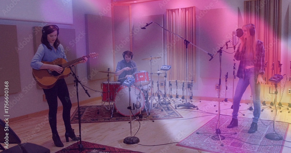 Fototapeta premium Recording three musicians strumming guitar, playing drums, singing in studio, with microphone gear