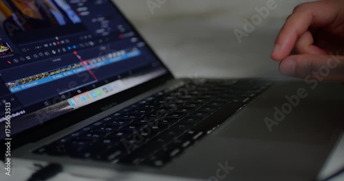 4K close-up of hand using laptop touchpad to edit video footage on professional software. Focus on creative workflow, remote work, digital content creation, and post-production.