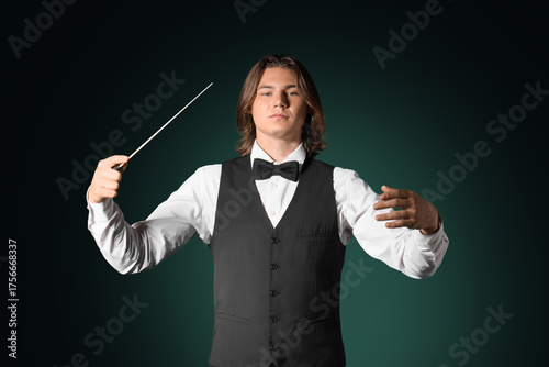 Male conductor on dark gree...