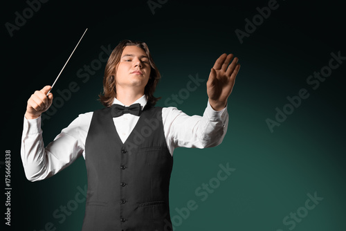 Male conductor on dark gree...