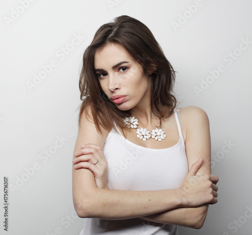 beautiful young woman wearing casual clothes, posing on light grey background.